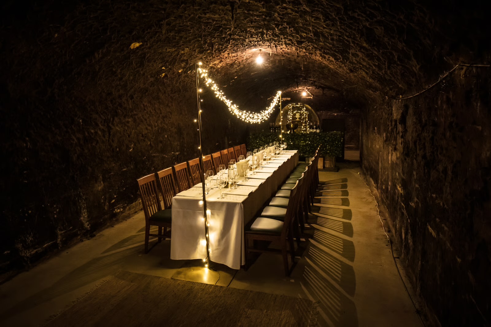 The Cellar — a candlelit vaulted stone room set for dinner